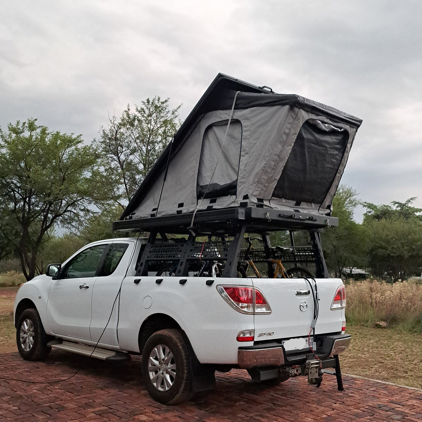 grey and black roof top tent on top of a Mazda 4x4